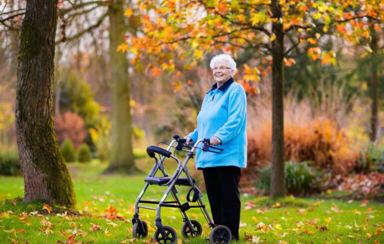 Polnische Pflegekraft begleitet Senior zu herbstlichen Aktivitäten im Park