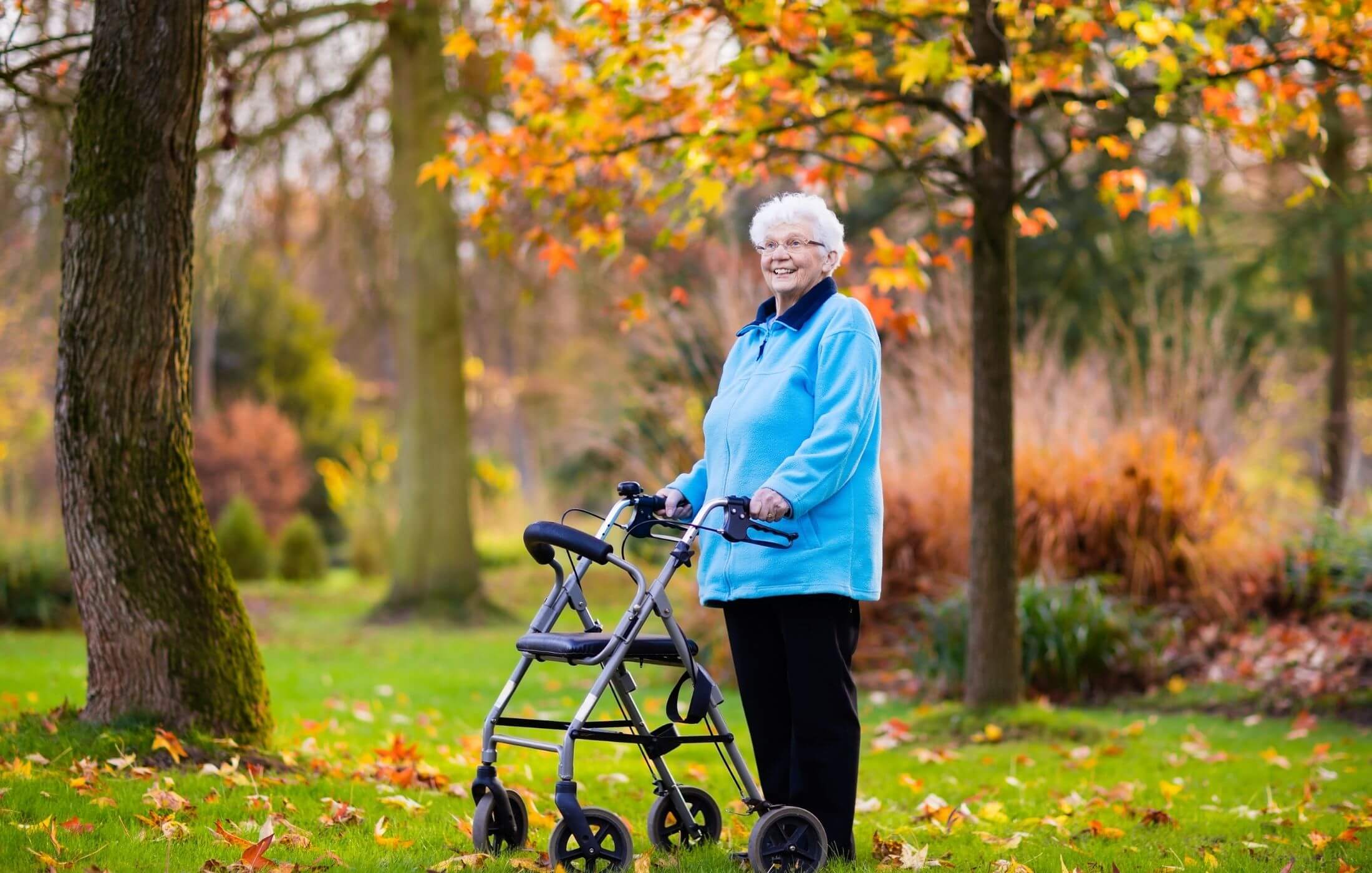 Polnische Pflegekraft begleitet Senior zu herbstlichen Aktivitäten im Park